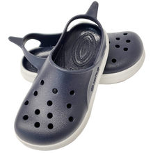 Sandalias Boatilus CLOGGY en azul marino y blanco, con diseño cómodo y moderno, visibles en la imagen.